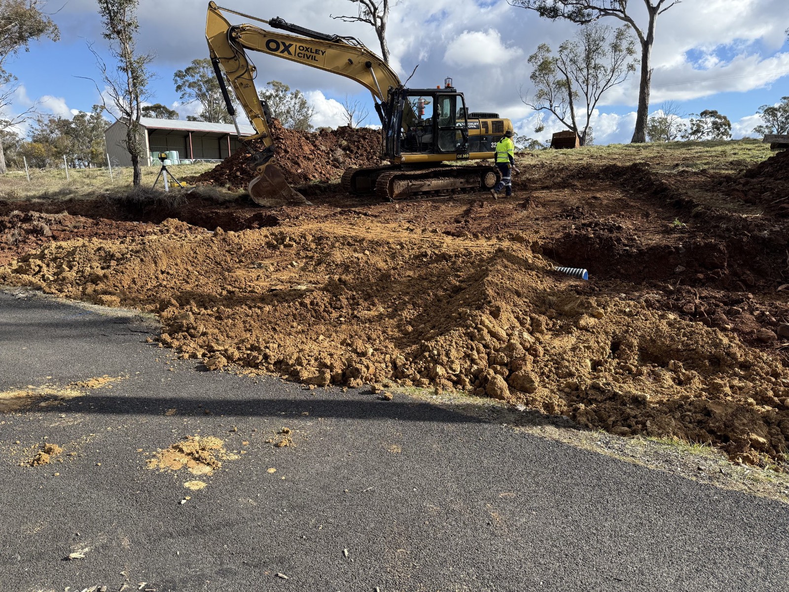 Excavator working a road shoulder drain
