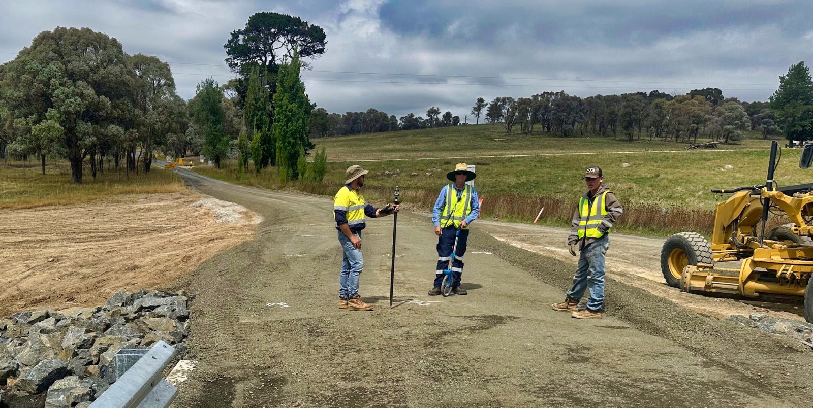 Crew setting out survey beside a guardrail