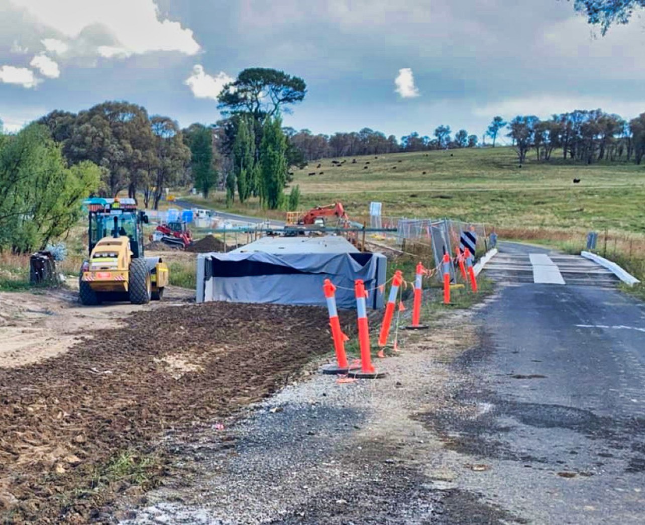 Grader and roller widening a rural road