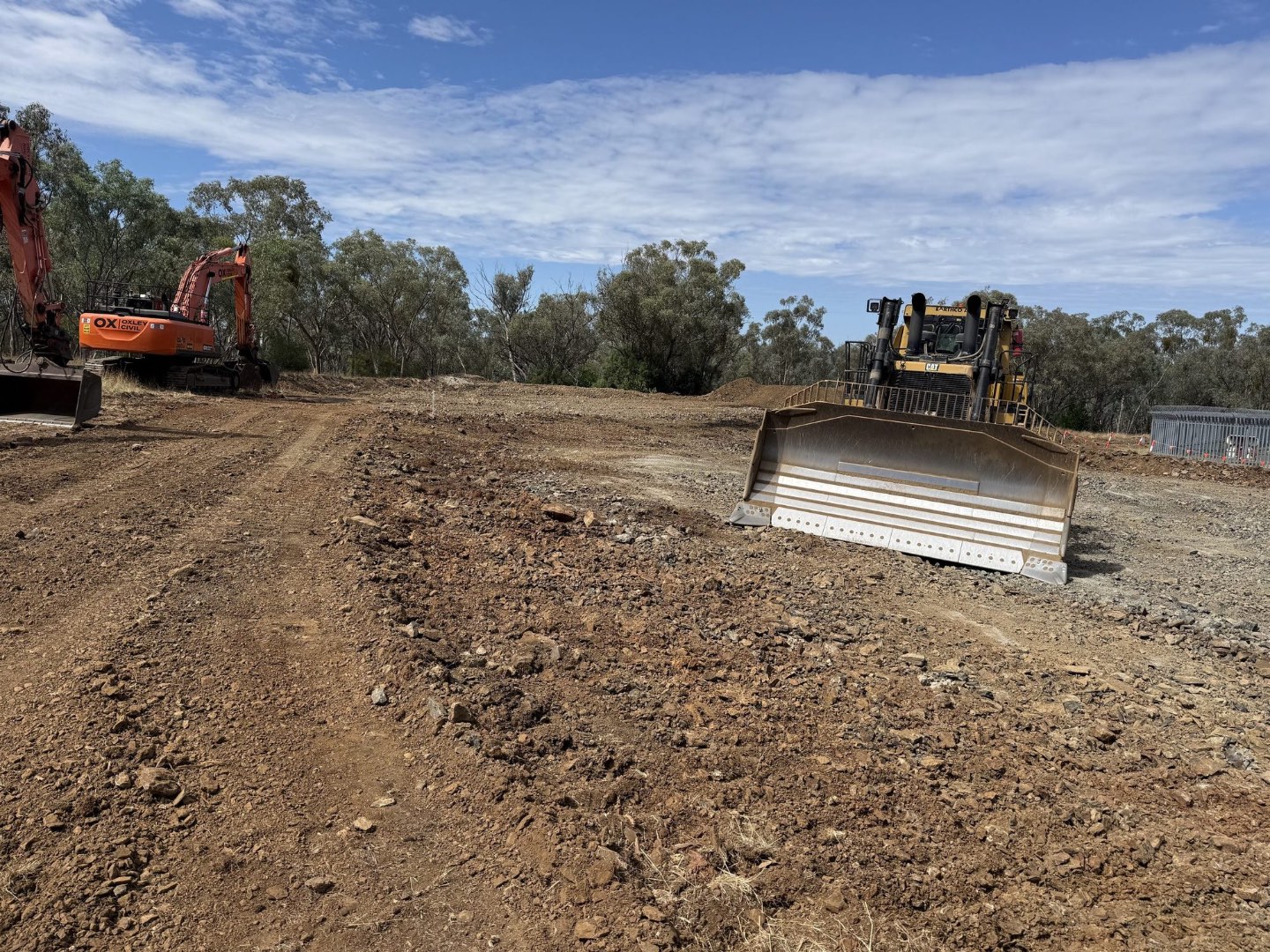 Dozer and excavator forming a pad