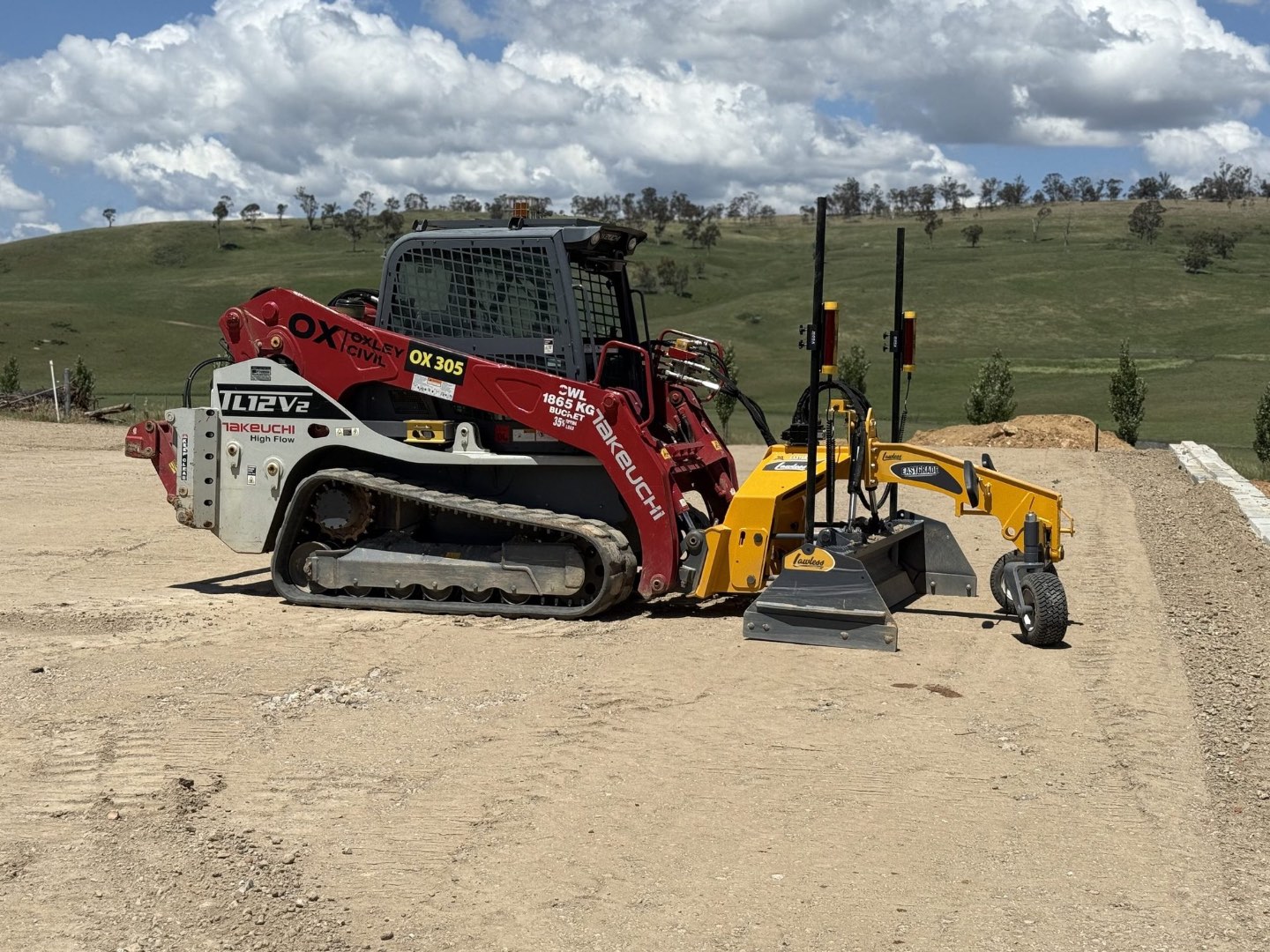 Skid steer laser grading a pad