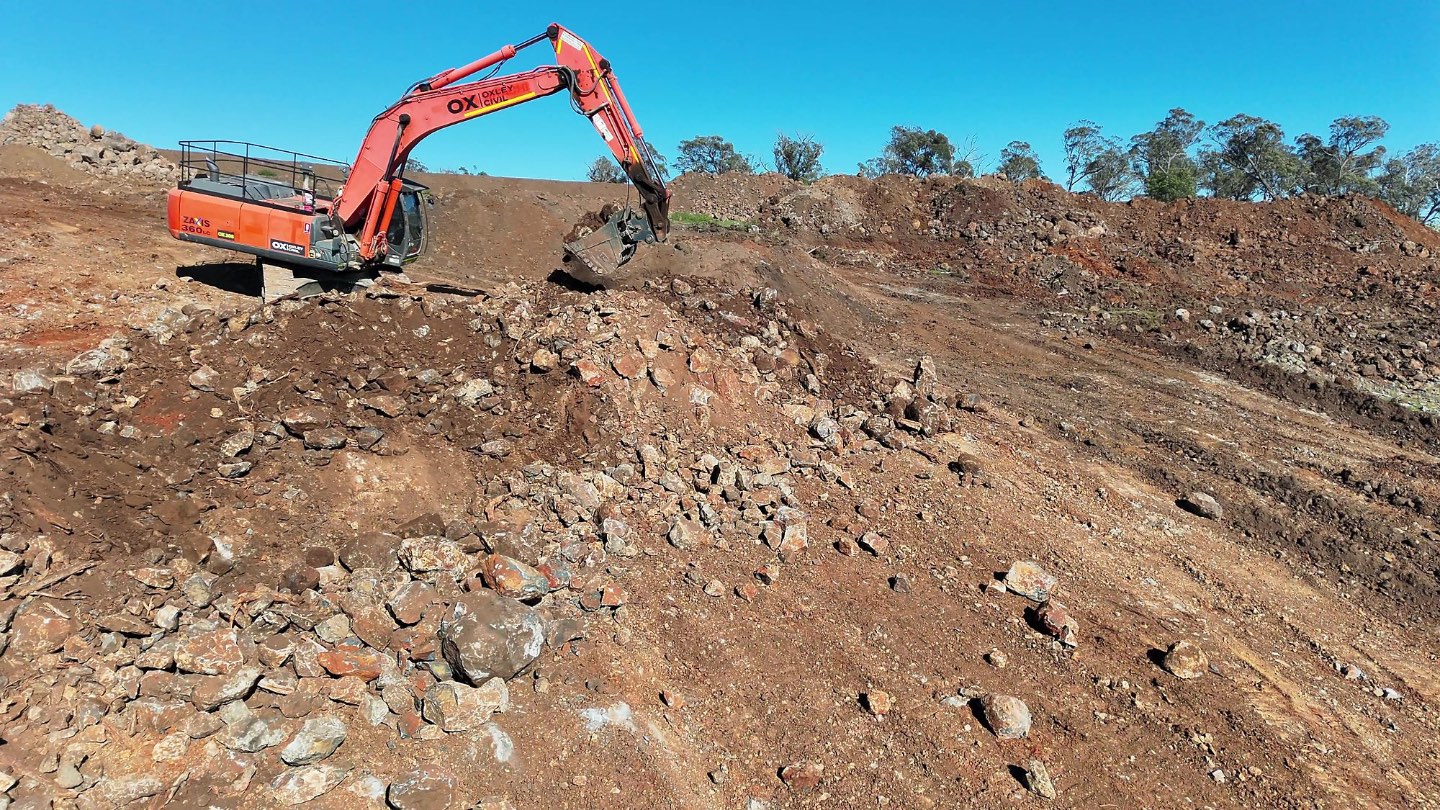 Excavator working rock