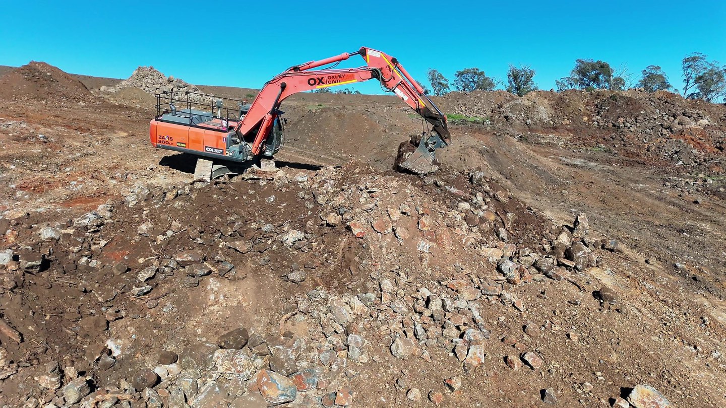 Excavator digging rock