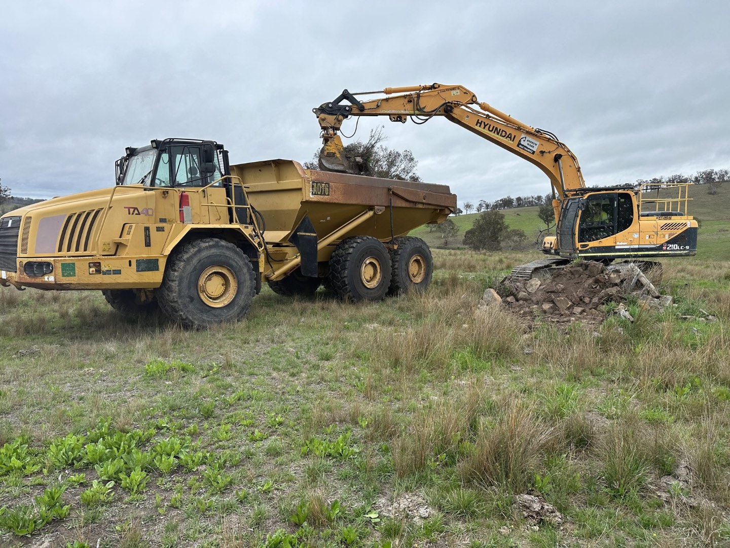 Excavator loading rock into the dump truck