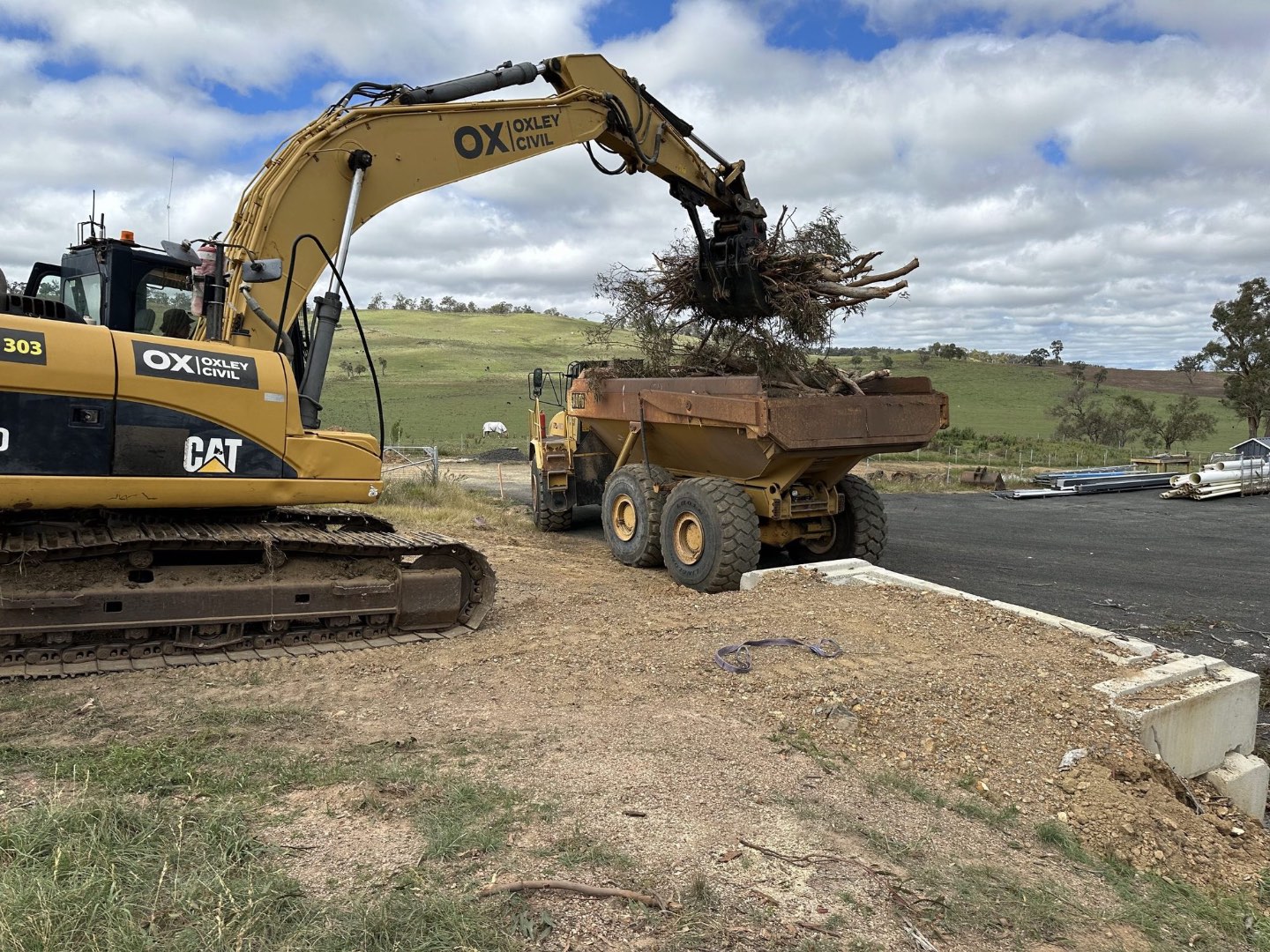 Oxley excavator loading stumps into the dump truck