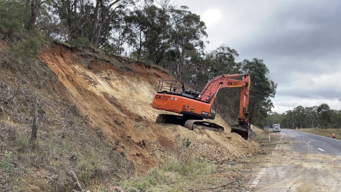 Excavator working the batter beside the road