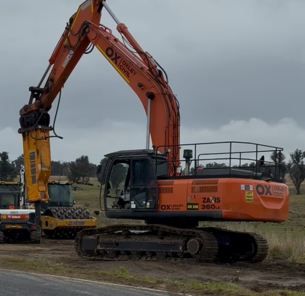 Zaxis 360 with breaker beside the roller