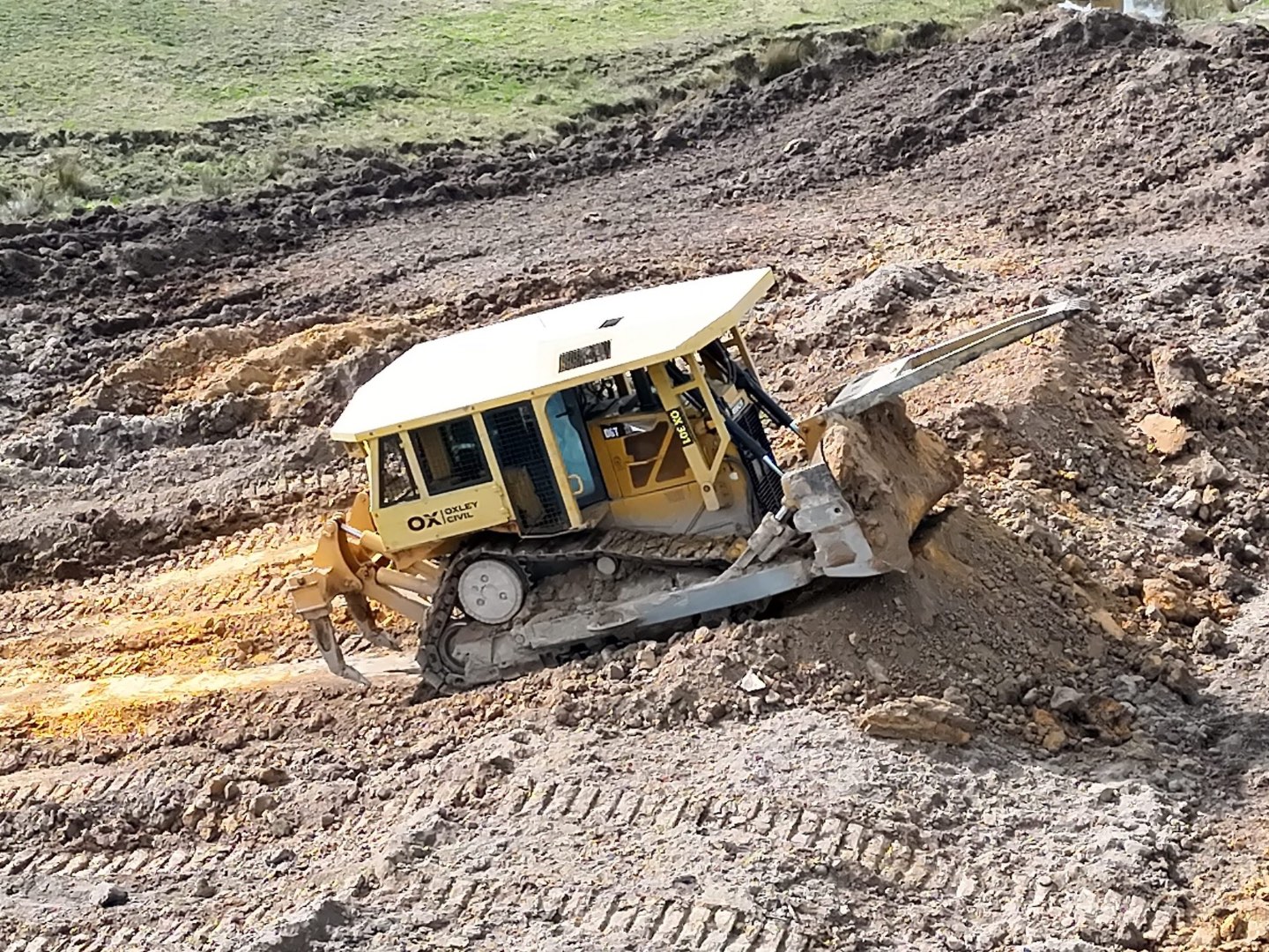 Dozer pushing spoil on a dam wall